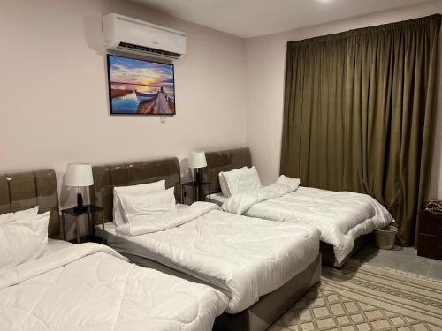 吉达منتجع شاطيء جوفالي GUVALI Beach شاليه طراز ميكانوس Siyal سيال سابقاً的酒店客房设有两张床和电视。
