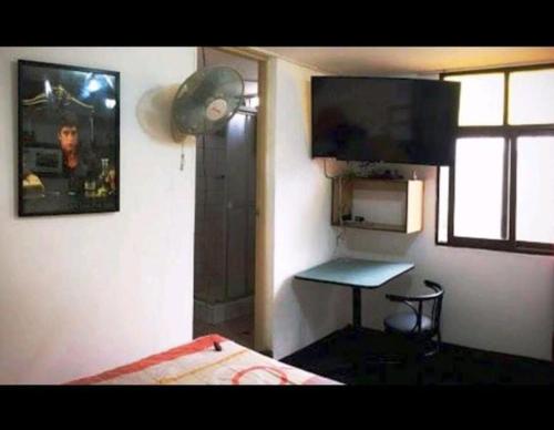 利马Hospedaje Miraflores 17的一间卧室配有一张床、一张桌子和一个窗户。