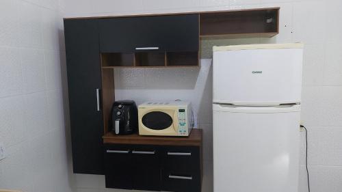 伯迪亚哥CASA DISPONÍVEL PARA TEMPORADA的一间带微波炉和冰箱的小厨房