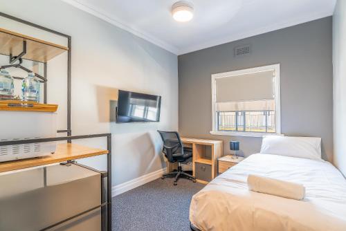 布里斯班K2 Brisbane的一间卧室配有一张床、一张桌子和一把椅子