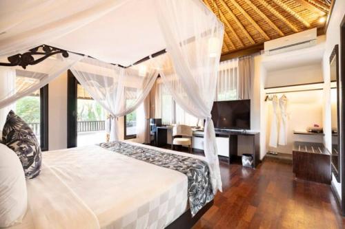 乌布乌布得达利酒店的一间卧室配有一张白色天蓬床