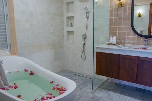 暹粒Ptas Songsaa by Amatak的浴室设有鲜花浴缸。
