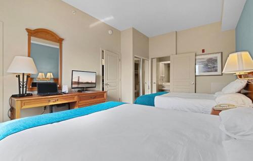 奥兰多Resort Hotel Condo-2 rooms near Theme parks - Free parks shuttle的一间卧室配有两张床和一张书桌及电视