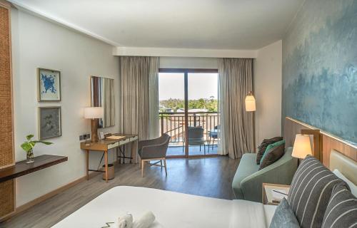 邦劳Modala Beach Resort的配有一张床和一张书桌的酒店客房