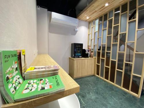 台北宏洲旅社HZ Hotel的一间设有书架和桌子的房间