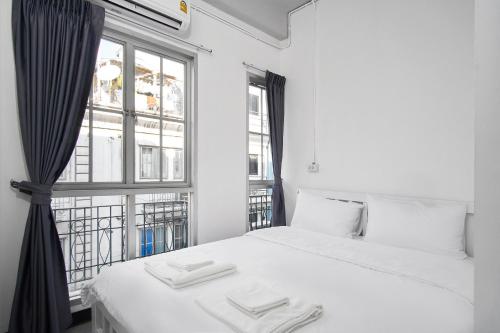 曼谷G5 Hostel的卧室配有白色的床和窗户。