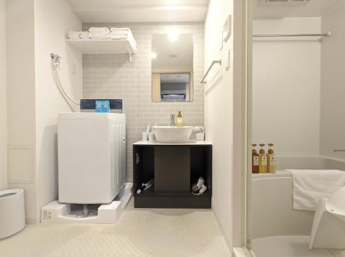 大阪ESLEAD HOTEL Osaka Tsuruhashi的白色的浴室设有水槽和浴缸。