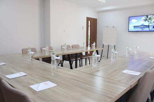 雅加达AZKA HOTEL Managed by Salak Hospitality的一间会议室,配有一张大木桌子和椅子