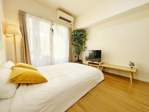 福冈Picolo Hakata的卧室配有一张白色大床和电视。