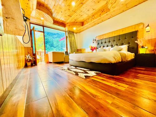马拉里Himalayan Nature Walk Resort, Manali的一间卧室设有一张大床和一个大窗户