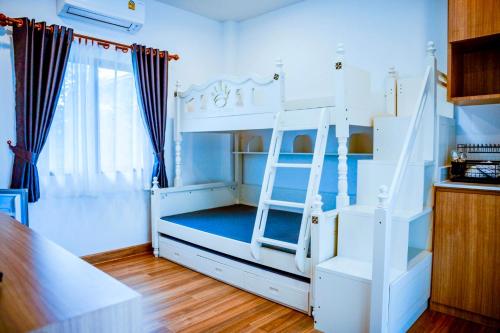 南府Nainan resotel ในน่าน รีโซเทล的客房内的白色双层床,带梯子