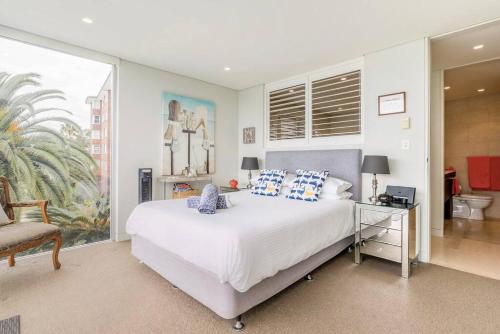 悉尼Balmoral Beach Beauty的卧室配有一张白色大床和一把椅子