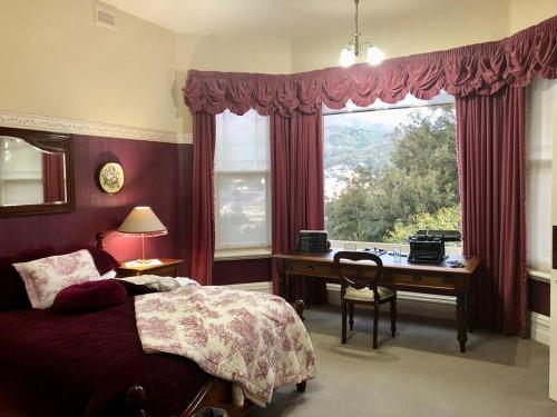 皇后镇彭哈纳住宿加早餐酒店的一间卧室配有一张床、一张书桌和一个窗户。