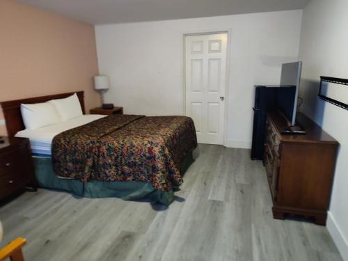 贝灵厄姆Shamrock Motel的一间卧室配有一张床、梳妆台和电视。