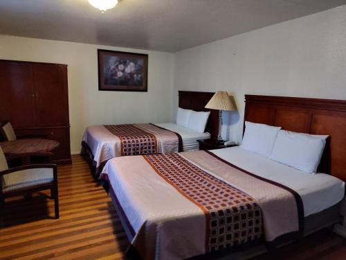 贝灵厄姆Shamrock Motel的酒店客房,配有两张床和椅子