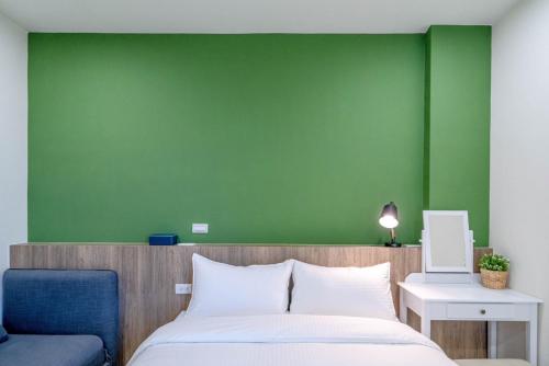 五结小宅生活的一间卧室设有绿色的墙壁和一张床