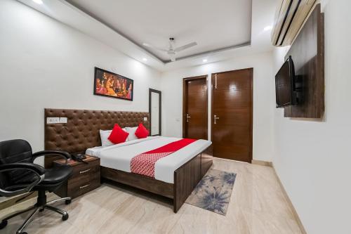 新德里OYO 72284 Premium Rooms Chhatarpur的一间卧室配有一张床、一张桌子和一把椅子