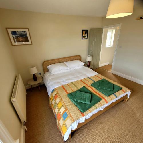 凯辛兰Pea Cottage的一间卧室配有一张带两张绿毛巾的床
