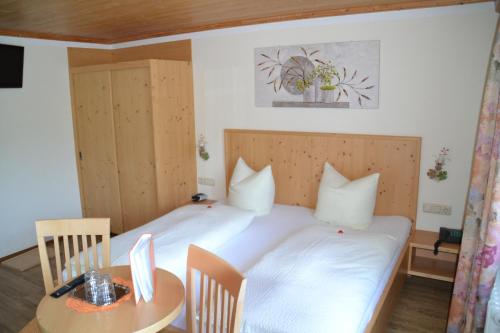齐勒谷地里德白恩德尔之家酒店的卧室配有白色的床和桌子