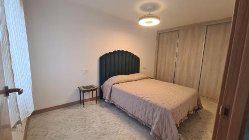 莫哈卡尔Vacaciones de ensueño的一间卧室配有一张床和一个绿色床头板