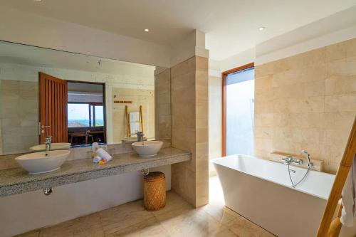 乌鲁瓦图Vivo Villas - Villa Vivo的浴室配有2个盥洗盆、浴缸和大镜子