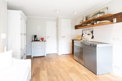 于斯德Haus Delft Argyra的厨房配有白色橱柜和不锈钢冰箱