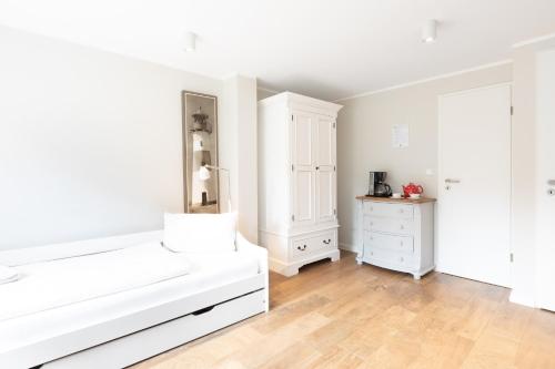 于斯德Haus Delft Argyra的白色卧室配有白色的床和梳妆台