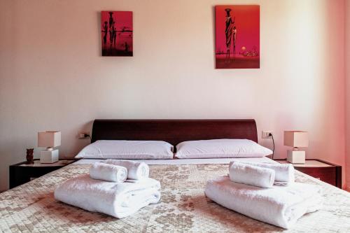San SperateCasa Azzurra的一间卧室配有两张床,床上配有毛巾