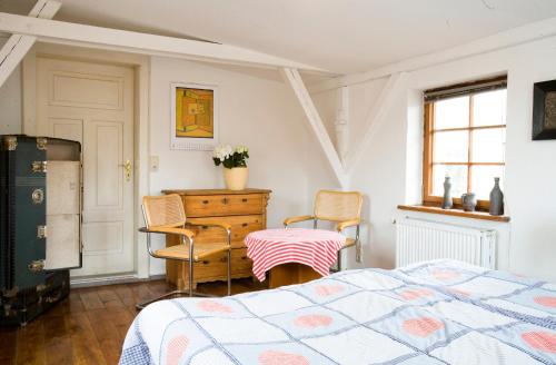 维斯马莱茵哈德酒店的卧室配有一张床和一张桌子及椅子