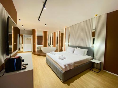 地拉那Capital Suites Center的一间带大床的卧室和一间浴室