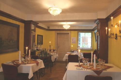 维斯马莱茵哈德酒店的一间带桌椅和吊灯的用餐室