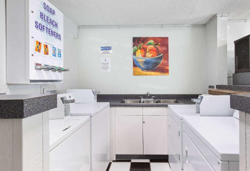 约翰逊城约翰逊城速8酒店的厨房配有水槽和一碗水果