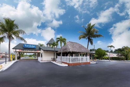 佛罗里达市佛罗里达市旅程住宿酒店的棕榈树建筑前的停车场