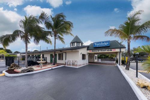 佛罗里达市佛罗里达市旅程住宿酒店的停车场内棕榈树的建筑