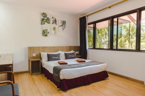 邦咯邦咯沙滩度假村的一间卧室设有一张床和一个大窗户