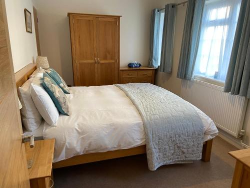 林德赫斯特The Bothy的卧室配有白色床和木柜