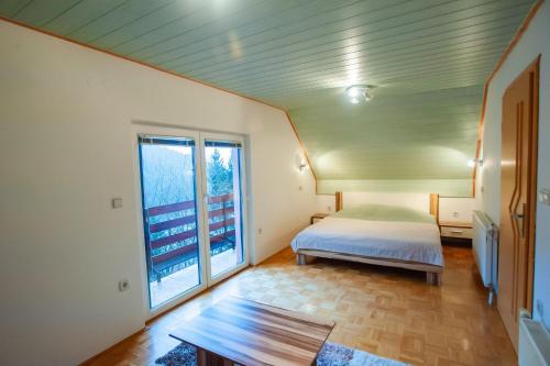 MislinjaCountry House & Spa的一间卧室设有一张床和一个大窗户