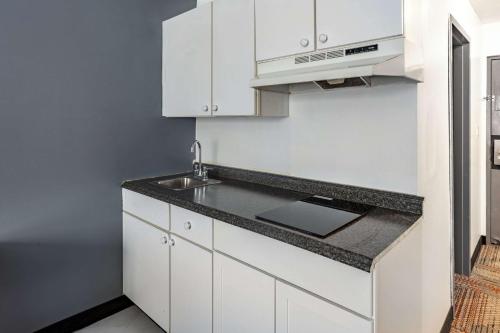 CaribouQuality Inn & Suites的厨房配有白色橱柜和水槽