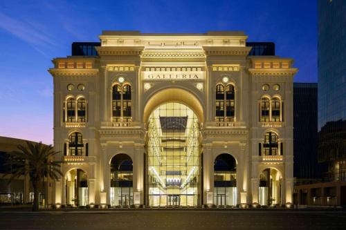 吉达The Hotel Galleria Jeddah, Curio Collection by Hilton的一座白色的大建筑,外墙有灯光