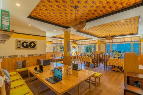 马拉里The Hosteller Manali, Old Manali的餐厅设有木桌和黄色椅子
