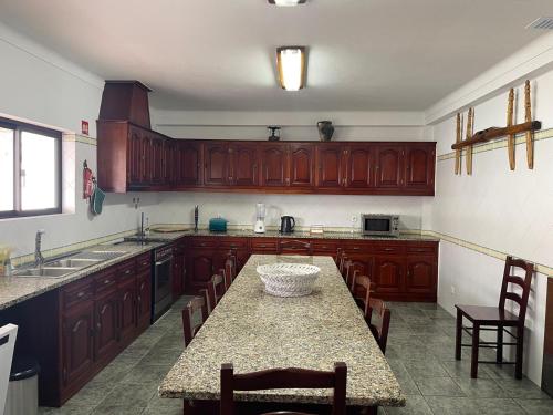 CavaleiroLUZ E SAL by Stay in Alentejo的厨房配有木制橱柜和桌椅