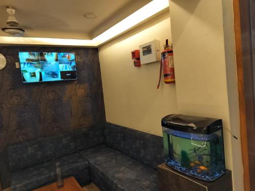 艾哈迈达巴德HOTEL RJ RESIDENCY的一间设有鱼缸和墙上电视的房间