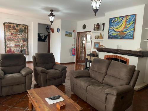 CavaleiroLUZ E SAL by Stay in Alentejo的客厅配有沙发、椅子和壁炉