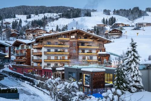 萨尔巴赫肯德勒酒店的一座大建筑,位于雪覆盖的山上