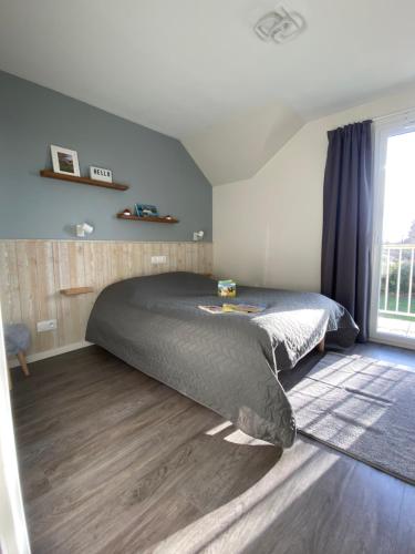 布朗维尔l'appartement la Pommeraie的一间卧室设有一张床和一个大窗户
