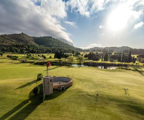 Muntanya la SellaLa casa de las Palmeras的享有带池塘的高尔夫球场的景色