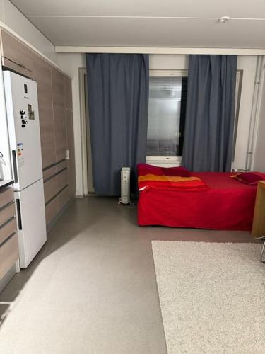 拉彭兰塔apartment的一间卧室配有红色的床和冰箱