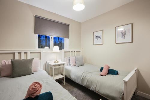 ManorRichmond House - 5 Bed, Sleeps 10, Great for Workers & Groups, Netflix & FREE Parking的一间卧室设有两张床和窗户。