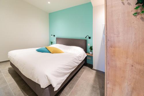 埃纲尔赫姆SYBA Gastenverblijf的一间卧室配有一张带白色床单和蓝色墙壁的床。