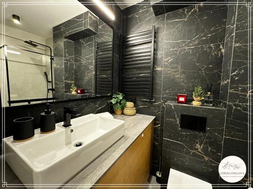 考斯赛力克Górska Enklawa的浴室设有白色水槽和黑色瓷砖